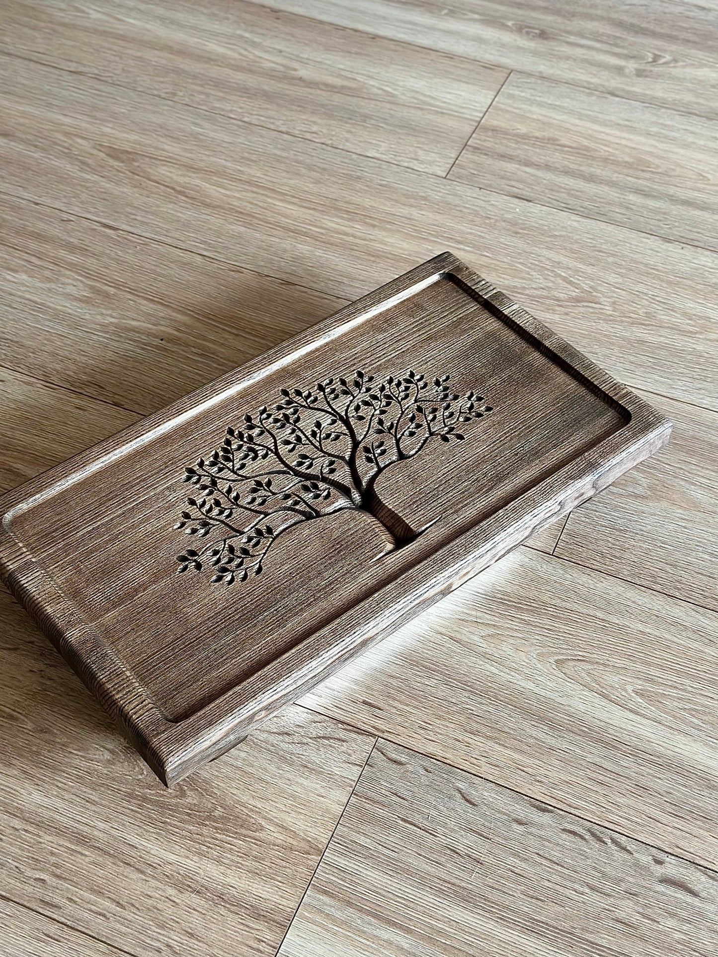 Wooden tray with tree design on a wooden floor