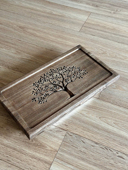 Wooden tray with tree design on a wooden floor
